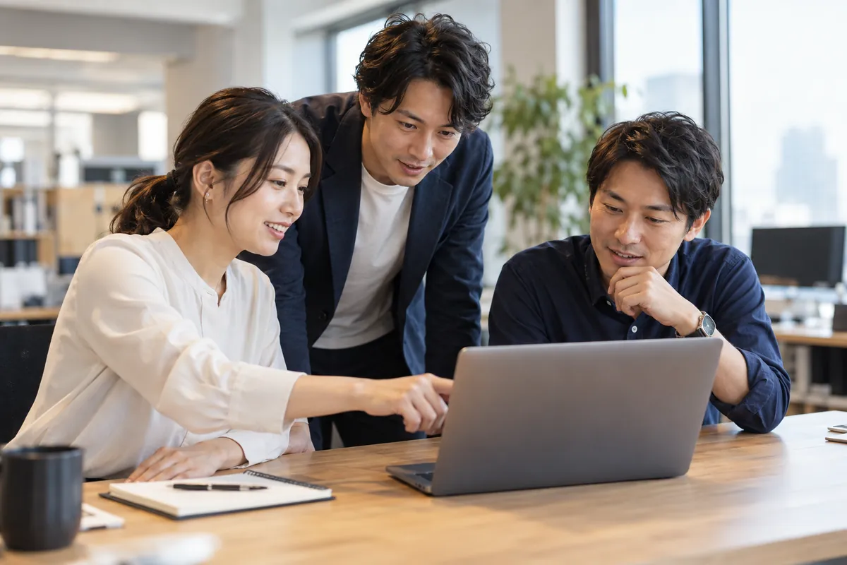 日本のオフィスでノートパソコンを見ながら使い方を確認する担当者たち